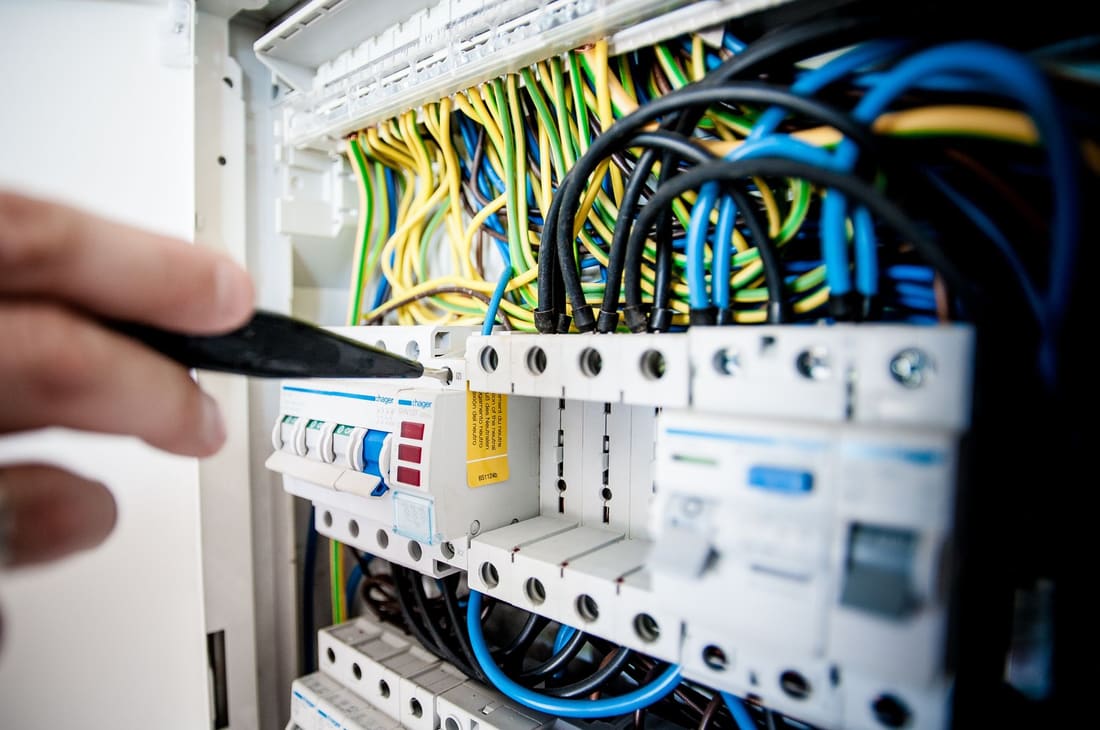 Engineer testing miniature circuit breakers in a distribution board