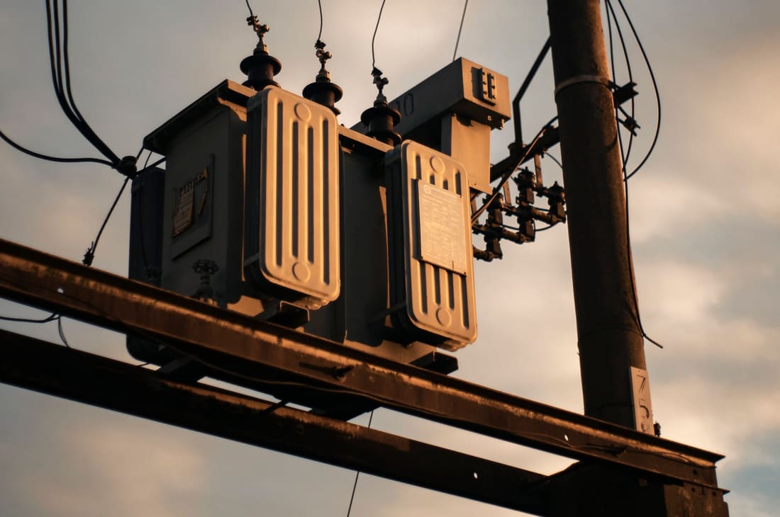 Pole-mounted distribution transformer against an open sky