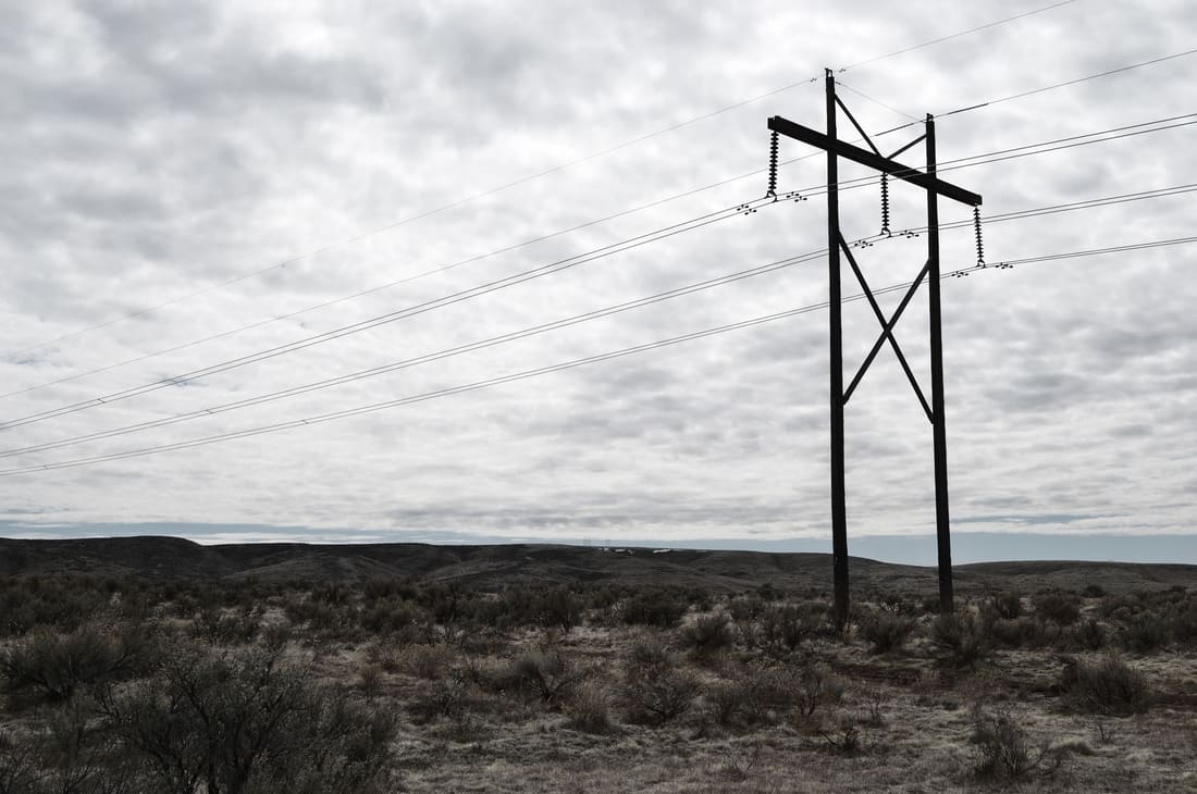 Distribution line silhouetted under a heavy sky