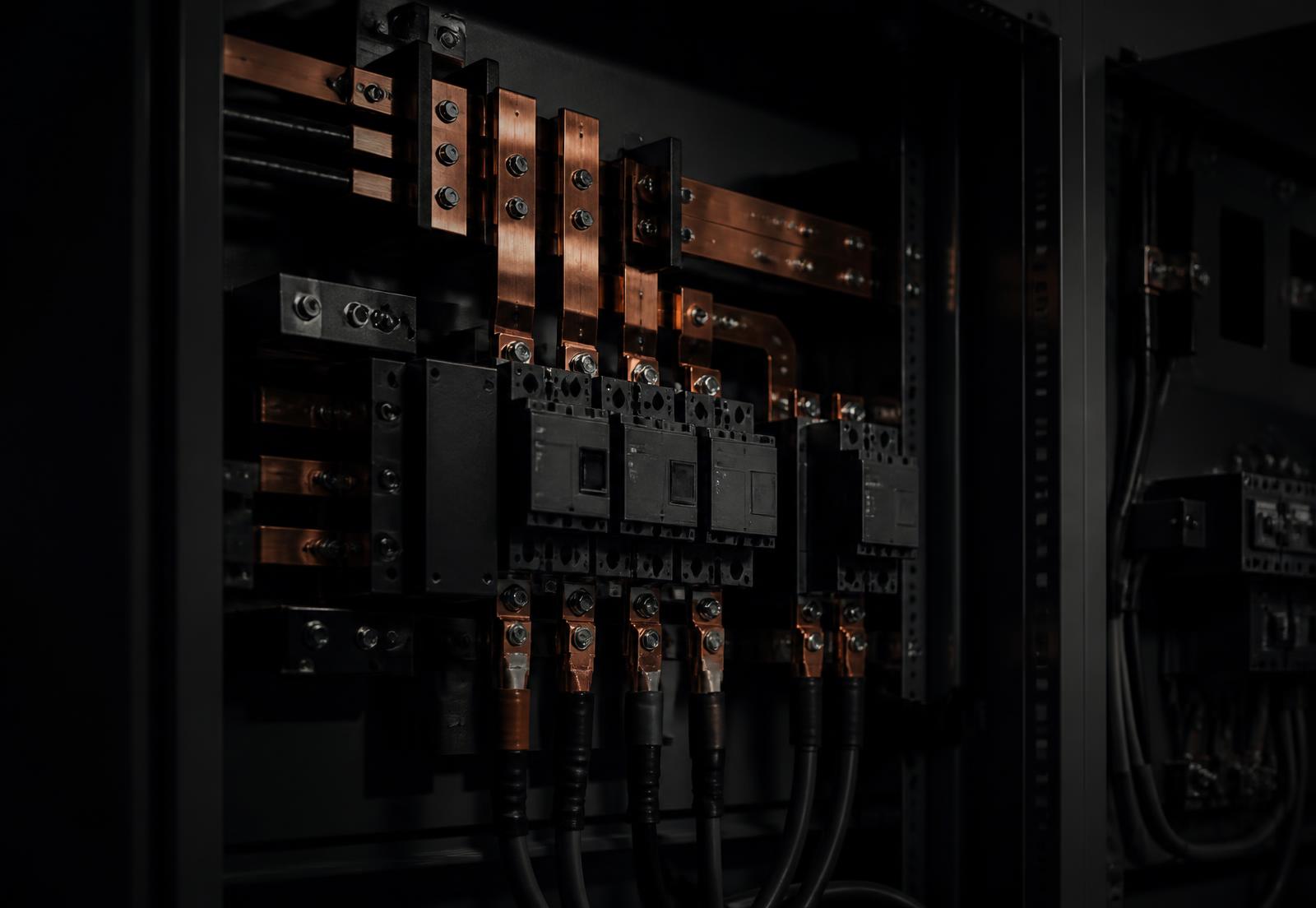Interior of an industrial switchgear panel with copper busbars and breakers