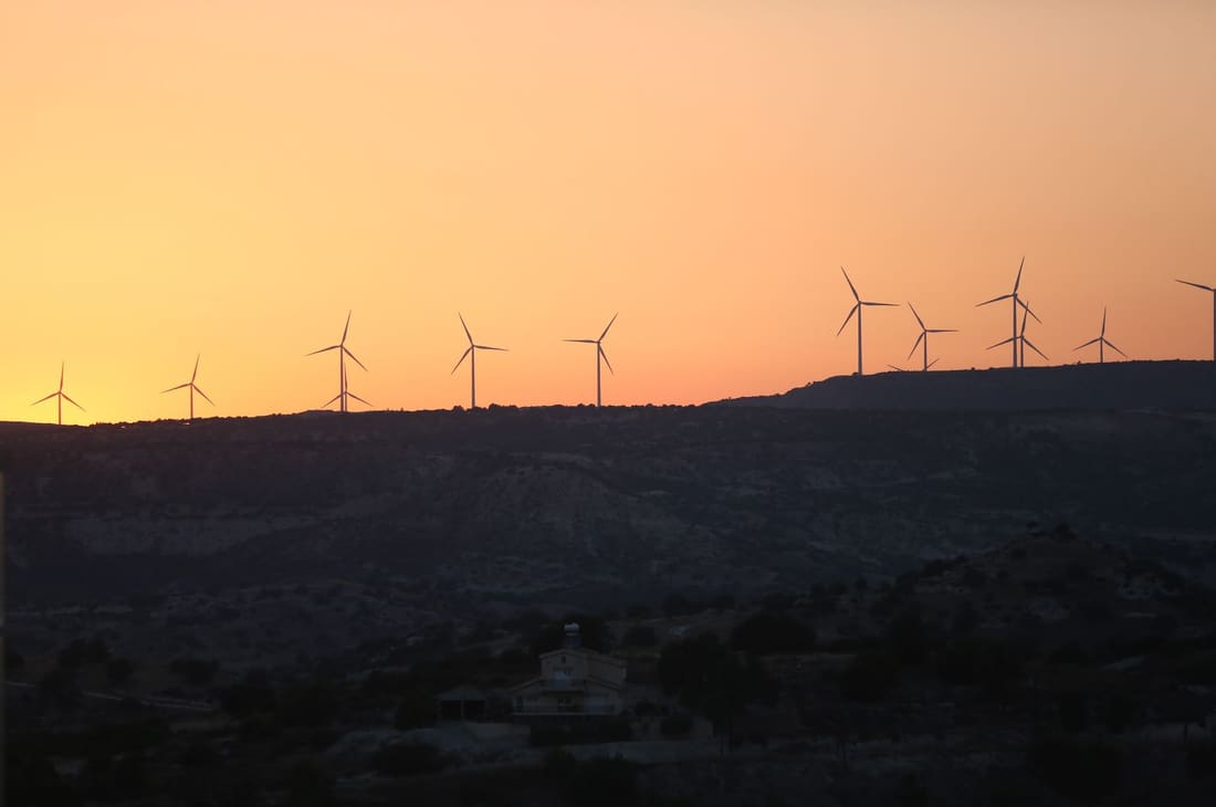 Wind turbines on a ridge at sunset